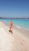 antenn se av kvinna gående på sandig tropisk strand förbi turkos hav på de gili öar, Indonesien. sommar resa livsstil scen med klar vatten, exotisk kust, och semester vibe. video