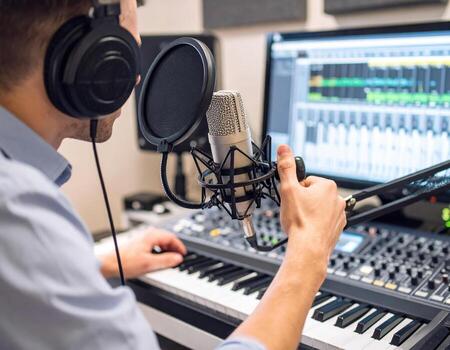 Young radio host prepares for high fidelity broadcast in modern studio, showcasing microphone and audio equipment. atmosphere is focused and creative, emphasizing art of sound production photo