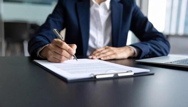 A person in a suit is signing a document photo