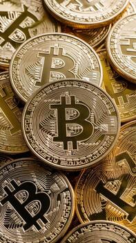 A collection of shiny gold and silver Bitcoin coins stacked together, symbolizing digital currency investment. photo