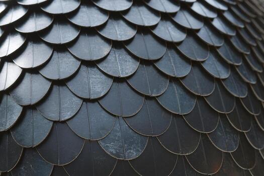 Close-up of textured metallic scales creating an artistic surface pattern with a dark finish. photo