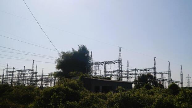 A large electrical power station with many high voltage lines photo