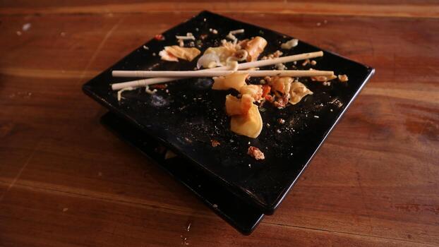 A table with a black square plate with food on it photo