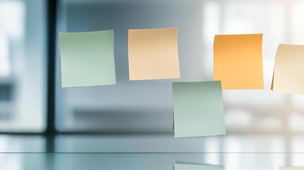 Collection of colorful sticky notes arranged on a glass surface in a modern office environment during the day photo