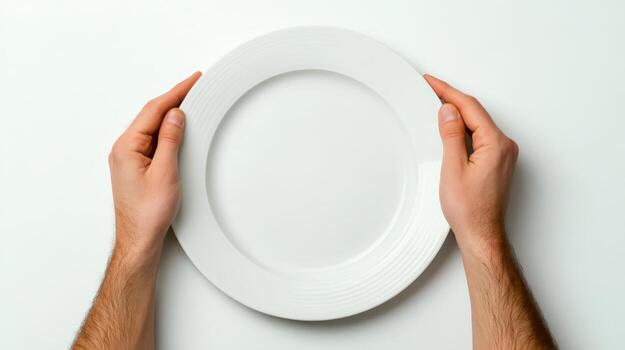 Hands holding an empty white plate on a light surface ready for serving food at a dining setting photo