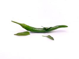 Fresco verde chile pimienta mentiras con vibrante hojas en contra un limpiar blanco antecedentes. foto
