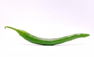 un vibrante verde chile pimienta curvas graciosamente en contra un brillante blanco fondo ofrecimiento especia. foto