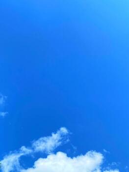 Expansive blue sky canvas dotted with soft white clouds creating a serene and peaceful atmosphere. photo