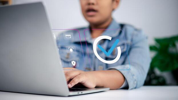Person working on laptop with checkmark, security, payment, and notification icons symbolizing online approval, digital transactions, and cybersecurity photo