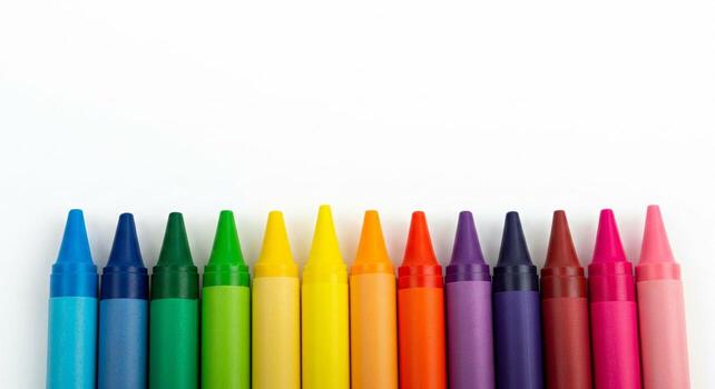Vibrant crayon array showcasing a spectrum of colors on a stark white background photo