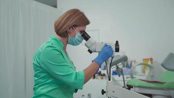 gynekolog användningar kolposkop. optisk enhet med förstoring designad för detaljerad undersökning av cervix, vagina, och vulva, hjälp i diagnos patologier och detekterings precancerös ändringar. video