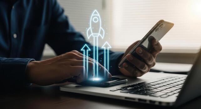 Businessman using smartphone and laptop with a rocket launch graphic symbolizing growth photo