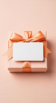 Peach gift box with orange ribbon and blank card for message photo