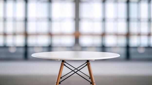 Modern round table in a bright room with large windows. photo