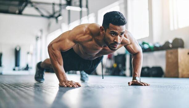 A man doing push ups in a gym photo