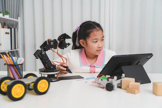 A girl using a tablet while working on her robotics project. photo