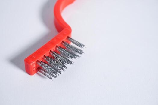Close up wire brush with red handle isolated on horizontal copy spaced white background. photo