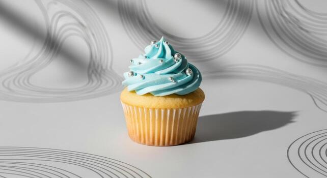 Delicious vanilla cupcake with blue frosting and silver pearls on a minimalist background photo