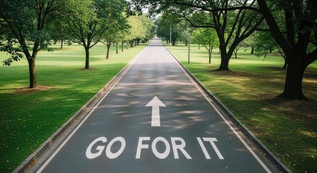 Straight paved road with GO FOR IT message and arrow through a green park landscape photo