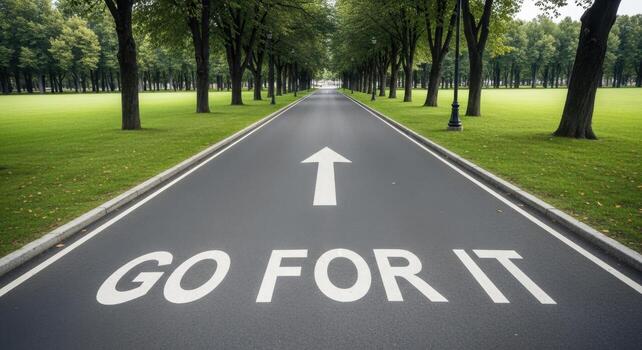 Straight paved road with GO FOR IT text and forward arrow in a green park photo