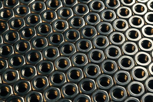 Gleaming metal hexagonal nuts arranged in an intricate industrial pattern background photo