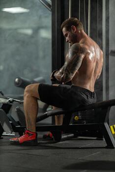 Man performing block pull exercise to the waist in modern gym setting during workout session photo
