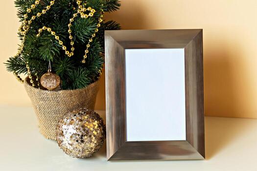 Mockup. Christmas. Empty picture frame positioned next to decorative Christmas tree adorned with golden beads and ornaments, creating cozy holiday atmosphere with ample copy space photo
