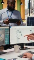 RD department colleagues brainstorming ways to make solar panels production lines more eco friendly. Teamworking technicians run simulation to optimize solar cells green energy levels, camera A video