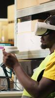vertikal svart personal användningar vr glasögon för 3d simulering driven förbi artificiell intelligens, stödjande beställa uppfyllelse och lager kontrollera. person övervakning paket spårning för sändning. kamera b. video