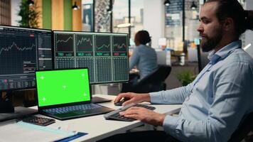 día comerciante en corretaje oficina análisis valores mercado cartas en aislado pantalla computadora portátil, haciendo comprar y vender decisiones experto lugares cliente pedidos utilizando comercio software en Bosquejo computadora portátil, cámara un video