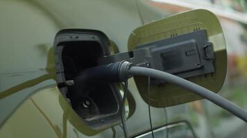Closeup of zero emission EV vehicle connected to charging dock, emphasizing commitment to cleaner environment. Electric car plugged into power supply, part of global push for decarbonizing transport video