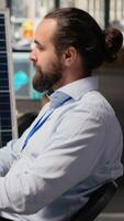 sorridente sostenibilità specialista si sviluppa pulito energia soluzioni, progettazione solare pannelli. allegro ingegnere nel ufficio simulando vento turbina aziende agricole per ottimizzare rinnovabile energia generazione, telecamera B video