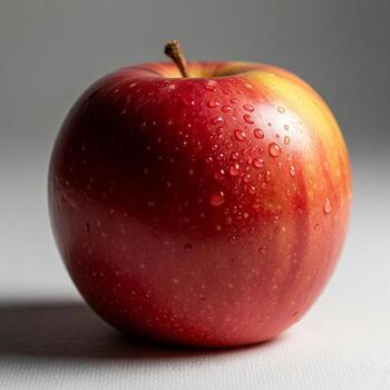 Realistic apple on soft surface, off-center, crimson and golden tones, dew drops, soft backlight, shallow depth of field, blurred background, photoreal studio lighting. photo