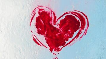 graffiti i de form av en röd hjärta, applicerad till en transparent yta, är tog bort förbi rengöring arbetare använder sig av vatten. låg vinkel. långsam rörelse. video