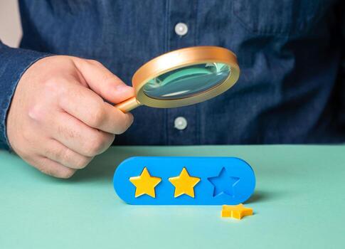 The man is studying the reasons for the loss of the third star in the rating. Bad reviews and quality or service issues. Fix the issues and restore client trust photo