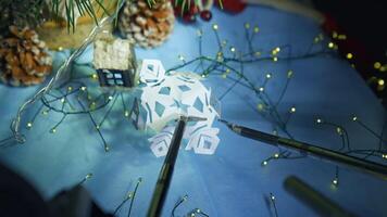 gadget humanoïde en train de préparer flocon de neige de papier tandis que en train de préparer à le Noël. tondu voir. futur les technologies concept video