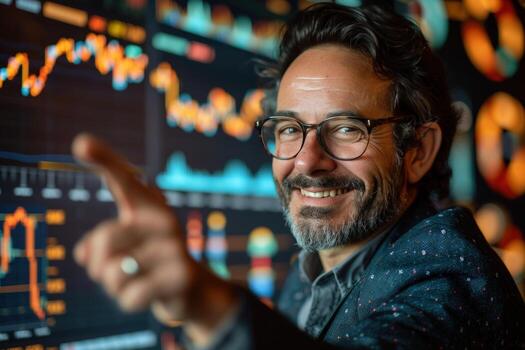 Smiling business professional points to data visualizations on large screens photo