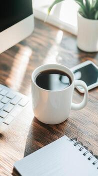 Office desk coffee and workspace scene with computer keyboard and notebook in natural sunlight photo