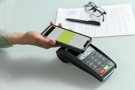 Hands using pos terminal and smart phone to complete nfc payment, financinal operation. photo