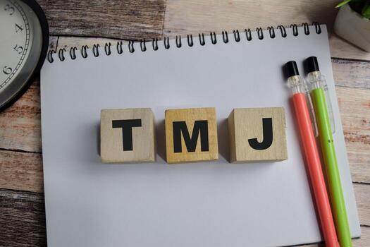 Concept of TMJ. Wooden block with words TMJ. Business and finance concept photo