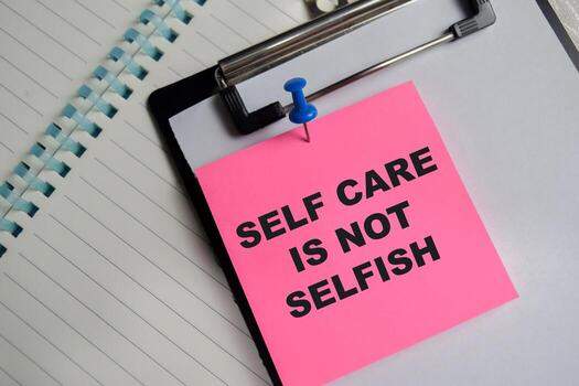 Concept of self care is not selfish write on sticky notes isolated on Wooden Table. photo