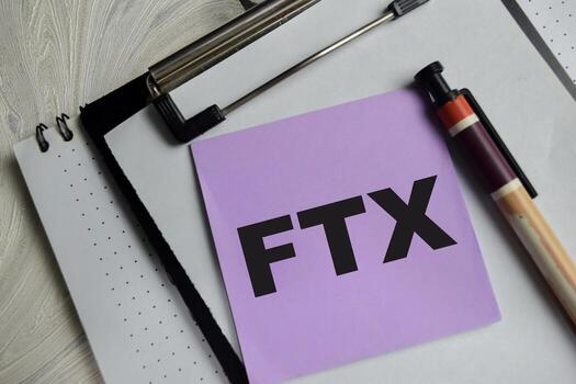 Concept of FTX write on sticky notes isolated on Wooden Table. photo