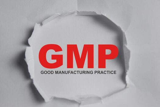 GMP - Good manufacturing practice Text written in torn paper photo