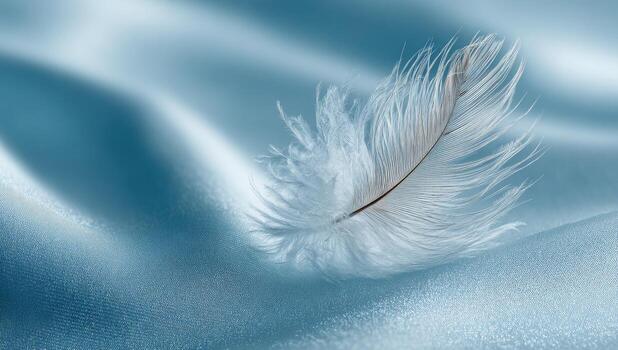 Delicate white feather rests on smooth, flowing teal fabric photo
