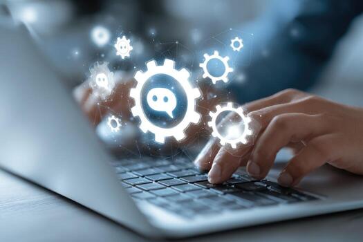 Hands typing on a laptop, with glowing gear and chat icons overlayed photo