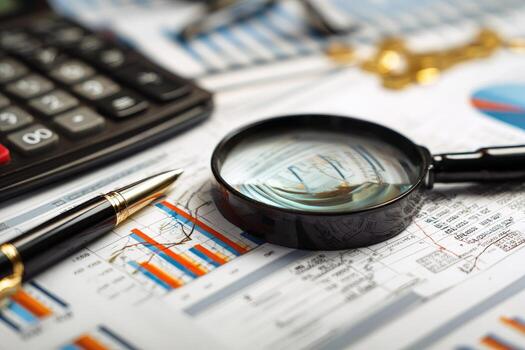 Business documents, charts, calculator, magnifying glass, and pen photo