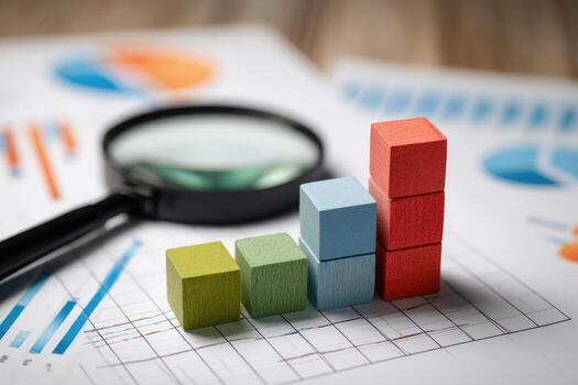 Wooden blocks forming a rising graph, analyzed with magnifying glass on financial documents photo