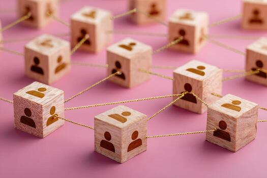 Wooden blocks with person icons connected by threads, forming a network on a pink background photo