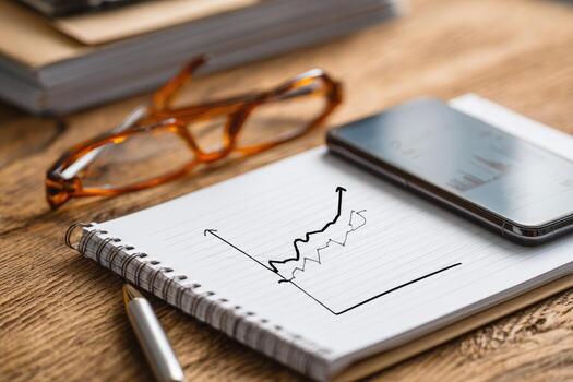 Hand-drawn graph on notepad, glasses, phone photo