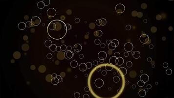 fascinerande slinga av gyllene cirklar flytande på en mörk bakgrund med lysande kanter och bokeh effekter. video